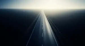 saas-debt-financing-revised-hero - SaasCEO.com A long, straight highway vanishing at the horizon with dark water on both sides and a bright light ahead.