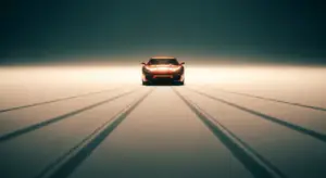 Front view of a red sports car centered on a glowing, reflective surface with long, converging shadows fading into a dark backdrop.